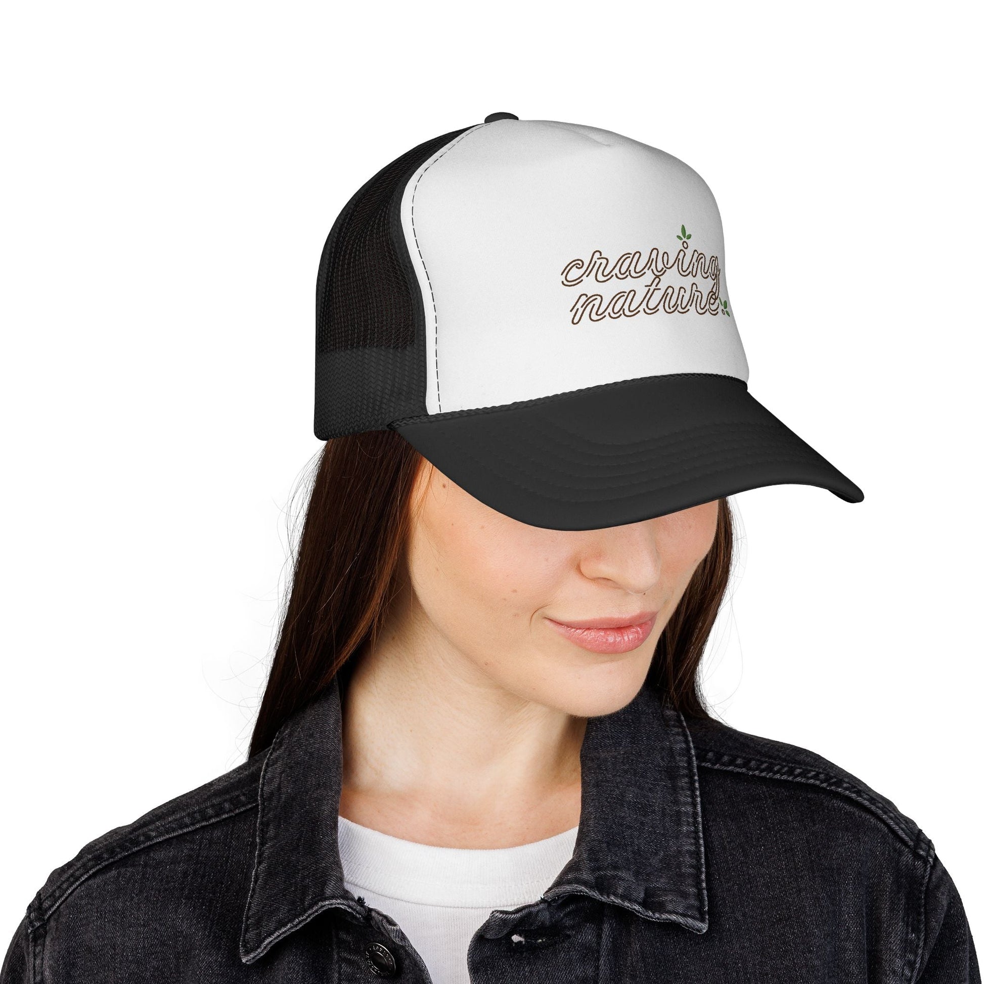 Model showing right side of Retro Trucker Cap, with black bill & mesh in back. White front with 'craving nature' design.