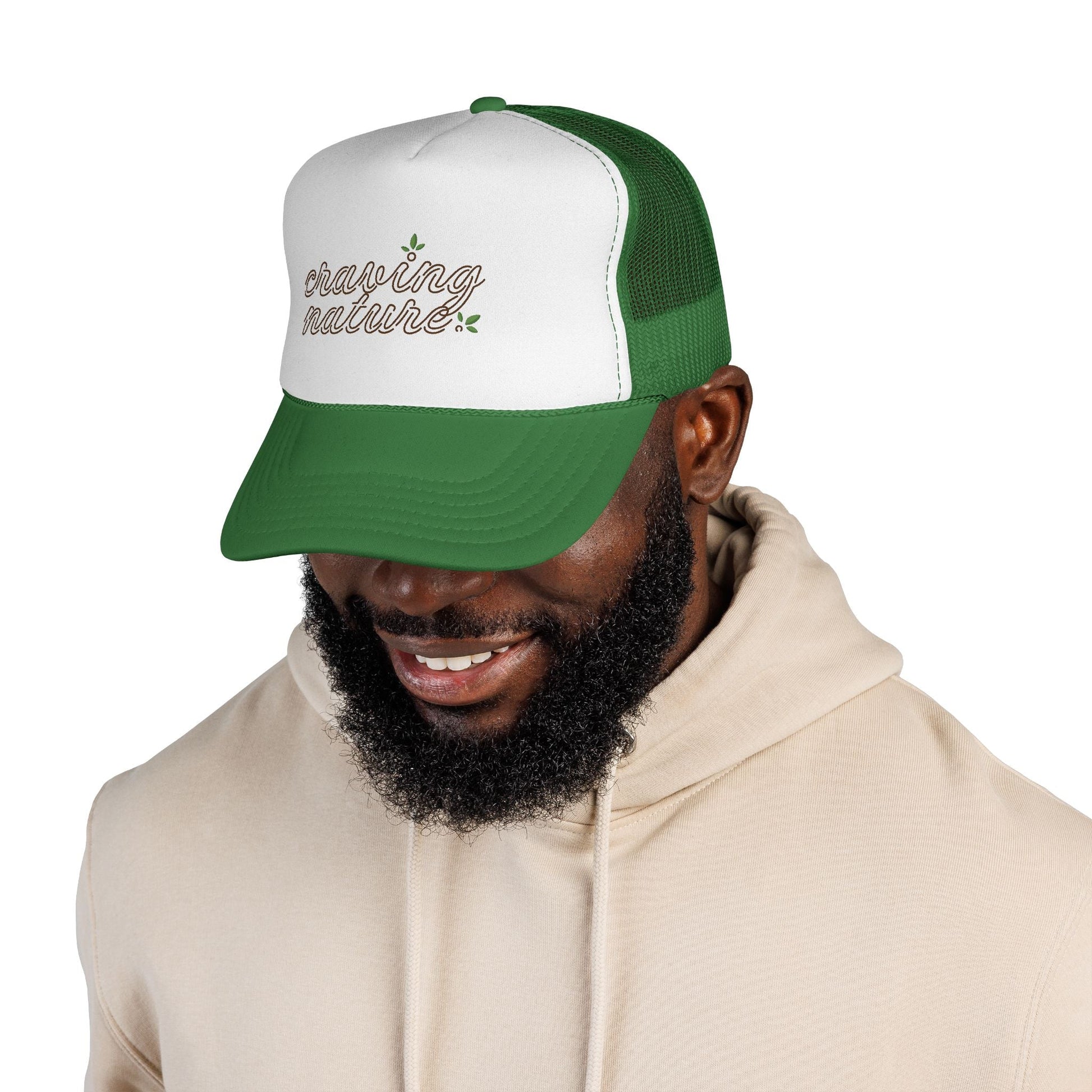 Model showing left side of Retro Trucker Cap, with green bill & mesh in back. White front with 'craving nature' design.